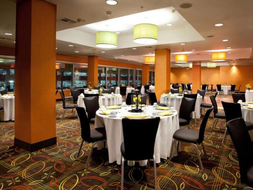 a banquet hall with white tables and chairs at 17 West Hotel, Ascend Hotel Collection in Tulsa