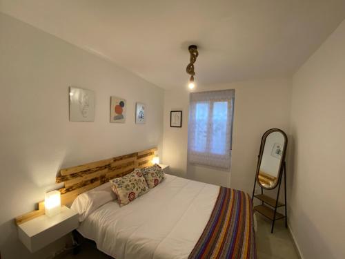 a small bedroom with a bed and a window at Casa Make in Málaga