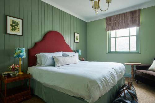 a bedroom with a large bed with a red headboard at The Retreat Elcot Park in Newbury