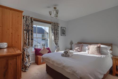 a bedroom with a bed with two stuffed animals on it at Acorn Cottage in Keswick