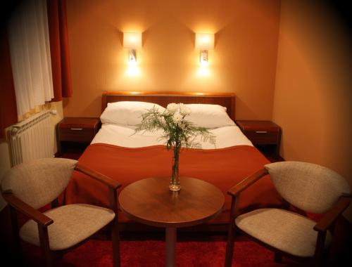 a hotel room with a bed with a table and chairs at Impresja in Borek Wielkopolski