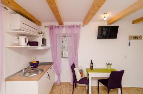 una pequeña cocina con fregadero y mesa en Lavender Garden Apartments, en Dubrovnik