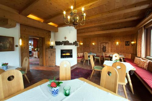 Habitación grande con mesas, sillas y chimenea. en Hotel Bruno, en Fügen