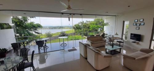 ein Wohnzimmer mit einem Sofa und einem Balkon in der Unterkunft Kondekar's WEEKEND HOME in Kolhapur