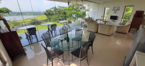 uma sala de jantar com uma mesa de vidro e cadeiras em Kondekar's WEEKEND HOME em Colhapur