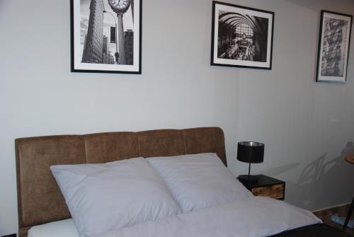 łóżko w pokoju z dwoma zdjęciami na ścianie w obiekcie Kryjówka Męża w mieście Zawiercie