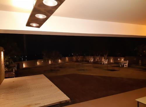 a rooftop patio at night with a table and chairs at Kondekar's WEEKEND HOME in Kolhapur