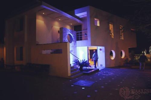 a person standing outside of a building at night at Kondekar's WEEKEND HOME in Kolhapur