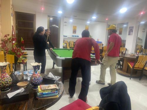 a group of people playing pool in a living room at Jordan Guest House in Wadi Musa