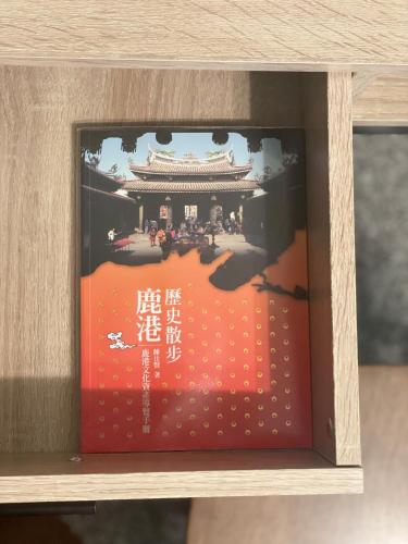 a book in a wooden box on a shelf at Hello Guesthouse in Lugang