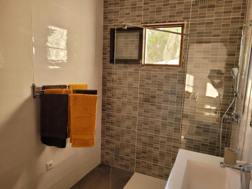 W łazience znajduje się umywalka oraz prysznic z pomarańczowymi ręcznikami. w obiekcie Apartamento de lujo Nerja w mieście Nerja
