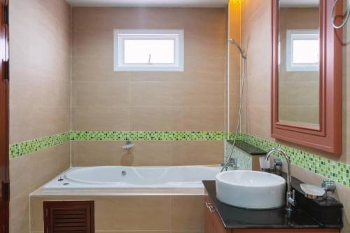 a bathroom with a tub and a sink and a window at Angel Pool Villa Phuket - SHA Extra Plus in Phuket Town