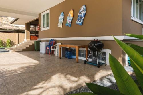 a room with a table and surfboards on the wall at Angel Pool Villa Phuket - SHA Extra Plus in Phuket Town