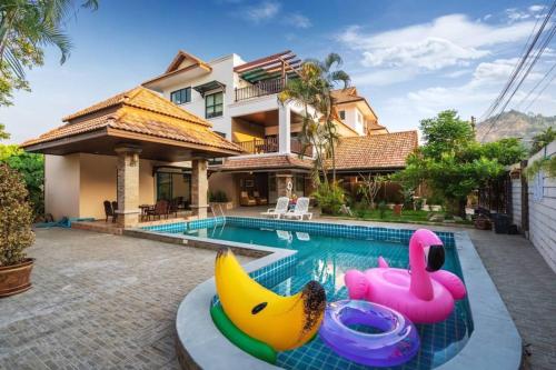 a house with a swimming pool with a toy banana at Angel Pool Villa Phuket - SHA Exta Plus in Phuket