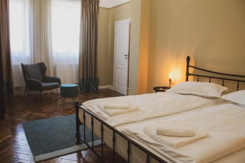 a bedroom with a large bed with a chair and a window at Allegro apartments city center in Oradea