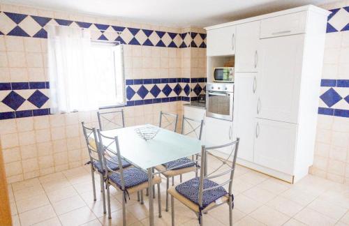 a kitchen with a table and chairs in a room at Casa da Ria in Cabanas de Tavira