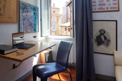 - un bureau avec un ordinateur portable et une chaise à côté d'une fenêtre dans l'établissement DomusAmor Navona, à Rome