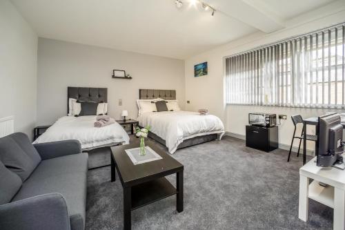 a living room with two beds and a couch at Huddersfield Central Lodge in Huddersfield