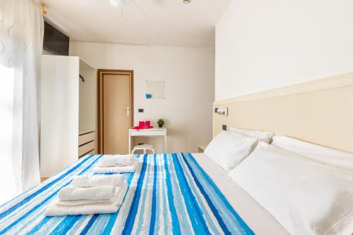 a bedroom with a bed with towels on it at Hotel Mignon Riccione Fronte Mare in Riccione