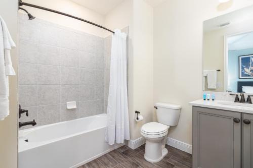 a bathroom with a tub and a toilet and a sink at Hakuna MaCottage in Orlando