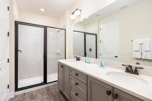 uma casa de banho com 2 lavatórios e um chuveiro em Hakuna MaCottage em Orlando