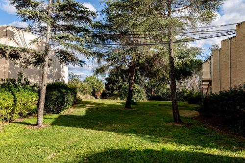 a green yard with trees and a building at Nes Ammim Hotel in Nes Ammim
