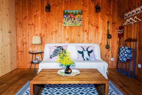 ein Wohnzimmer mit einem weißen Sofa und einem Tisch in der Unterkunft Cabane MIMI in Arès