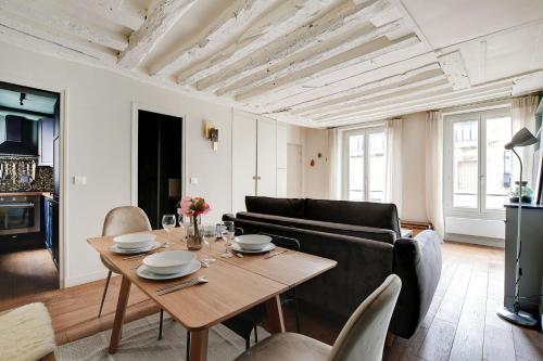 un salon avec une table et un canapé dans l'établissement Chic apartment -1BR-4P- Haut Marais - République, à Paris