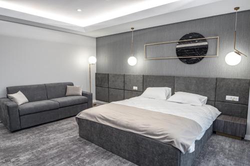 a bedroom with a bed and a couch at Hotel Caprice in Bacău