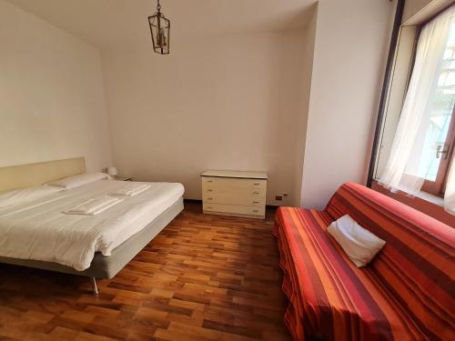 a bedroom with a bed and a red couch at BRERA - ForoBuonaparte Cozy apartment in Milan