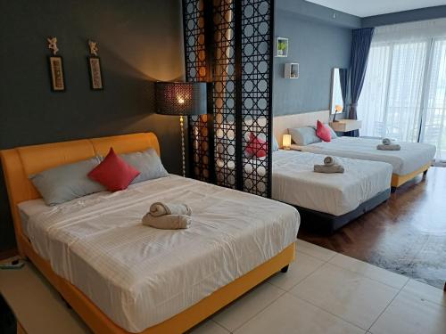 sypialnia z 2 łóżkami i ręcznikami w obiekcie cozy seaview 5 studio apartment w mieście Tanjong Tokong