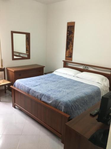 um quarto com uma cama, uma secretária e um espelho em Appartamento MIRAMARE em Ventimiglia