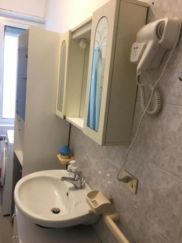 uma casa de banho com um lavatório e um secador de cabelo em Appartamento MIRAMARE em Ventimiglia