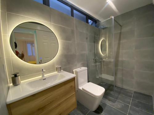 a bathroom with a sink and a toilet and a mirror at Les Cerisiers The Cherry Trees in Flic-en-Flac