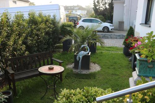 a yard with a bench and a table and some plants at Rooms in Düsseldorf near the Airport/Fair in Düsseldorf