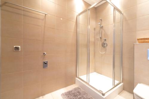 a shower with a glass door in a bathroom at Apartament Karmelowy z tarasem - Dream Apart in Wisła