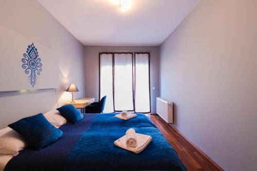 a bedroom with a large blue bed with towels on it at Apartament Karmelowy z tarasem - Dream Apart in Wisła