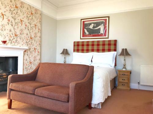 um quarto com uma cama, um sofá e uma lareira em 17 Burgate em Pickering