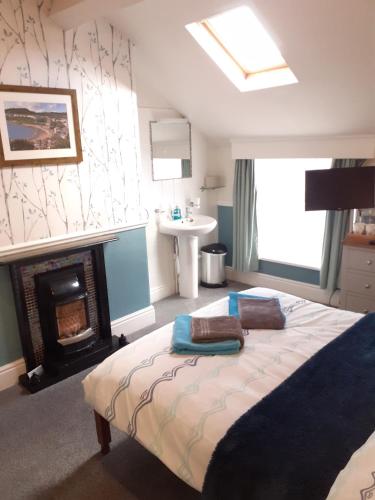 a bedroom with a bed with a fireplace and a sink at The Beaches in Scarborough