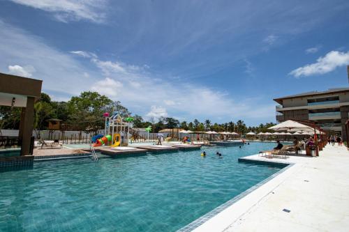 a large swimming pool with people in the water at Ipioca Beach Resort Maceió in Maceió