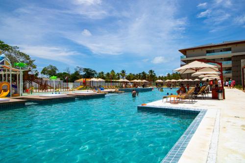 una piscina en un complejo con gente en el agua en Ipioca Beach Resort en Ipioca