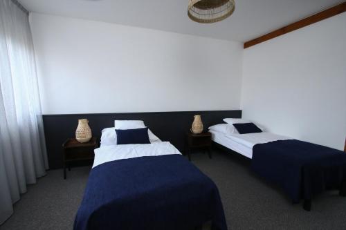 two beds in a room with blue and white at Jonathan Bed&Pizza in Komárom