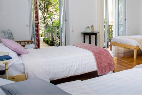 a room with three beds and a balcony at WISTERIA HOUSE in Brunate