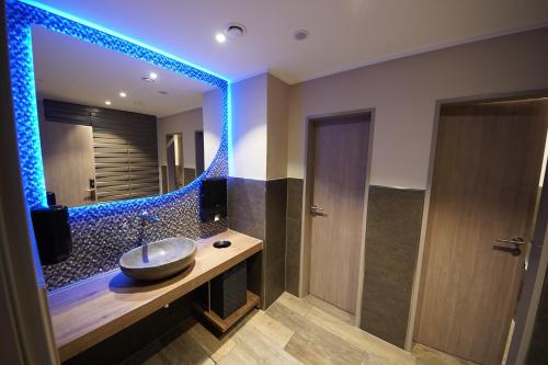 a bathroom with a sink and a large mirror at Hotel Am Markt Nordenham in Nordenham
