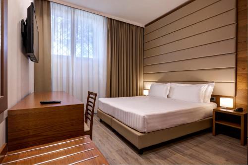 a hotel room with a bed and a desk at Occidental Aurelia in Rome