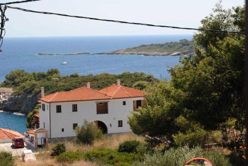 a white house with a view of the ocean at Dimitra's Apartment in Votsi