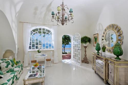 a living room with a couch and a chandelier at Villa Boheme Exclusive Luxury Suites in Positano