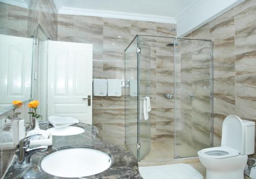 a bathroom with a toilet and a glass shower at Weston Hotel in Nairobi