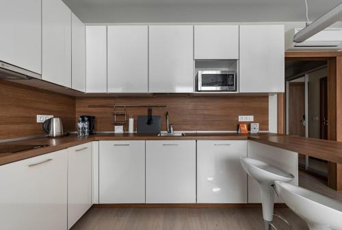 uma cozinha com armários brancos e um micro-ondas em Апарт-отель YE'S Mitino em Moscou