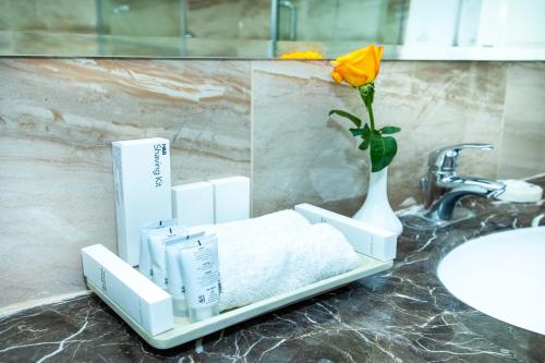 a bathroom counter with a vase with a flower in it at Weston Hotel in Nairobi